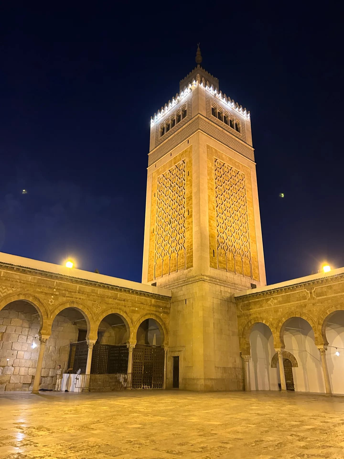 Un minaret illuminé à la nuit tombée